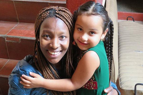 Noks Shabalala和她在危地马拉神学院传教队工作时遇到的一个小女孩微笑.