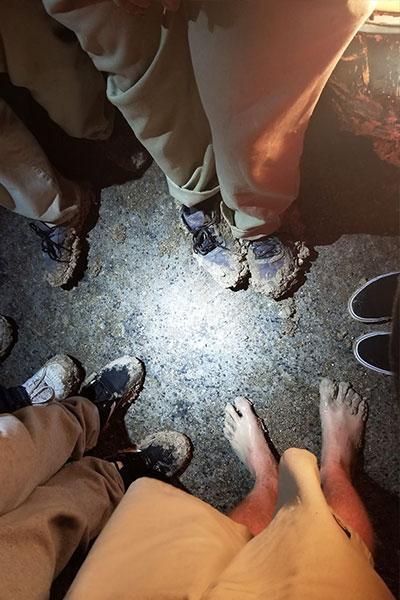 俯视图，布伦达和男孩们站成一圈，沾满泥巴的脚