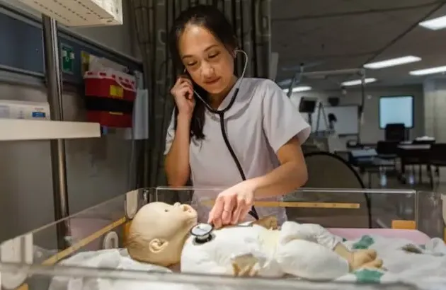 Nursing student with practice baby dummy